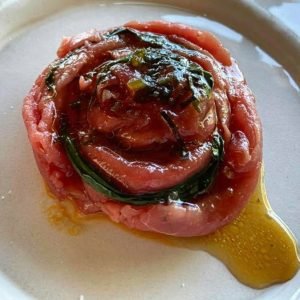 Raw meat dressed in sesame oil, wild garlic, puffed black rice